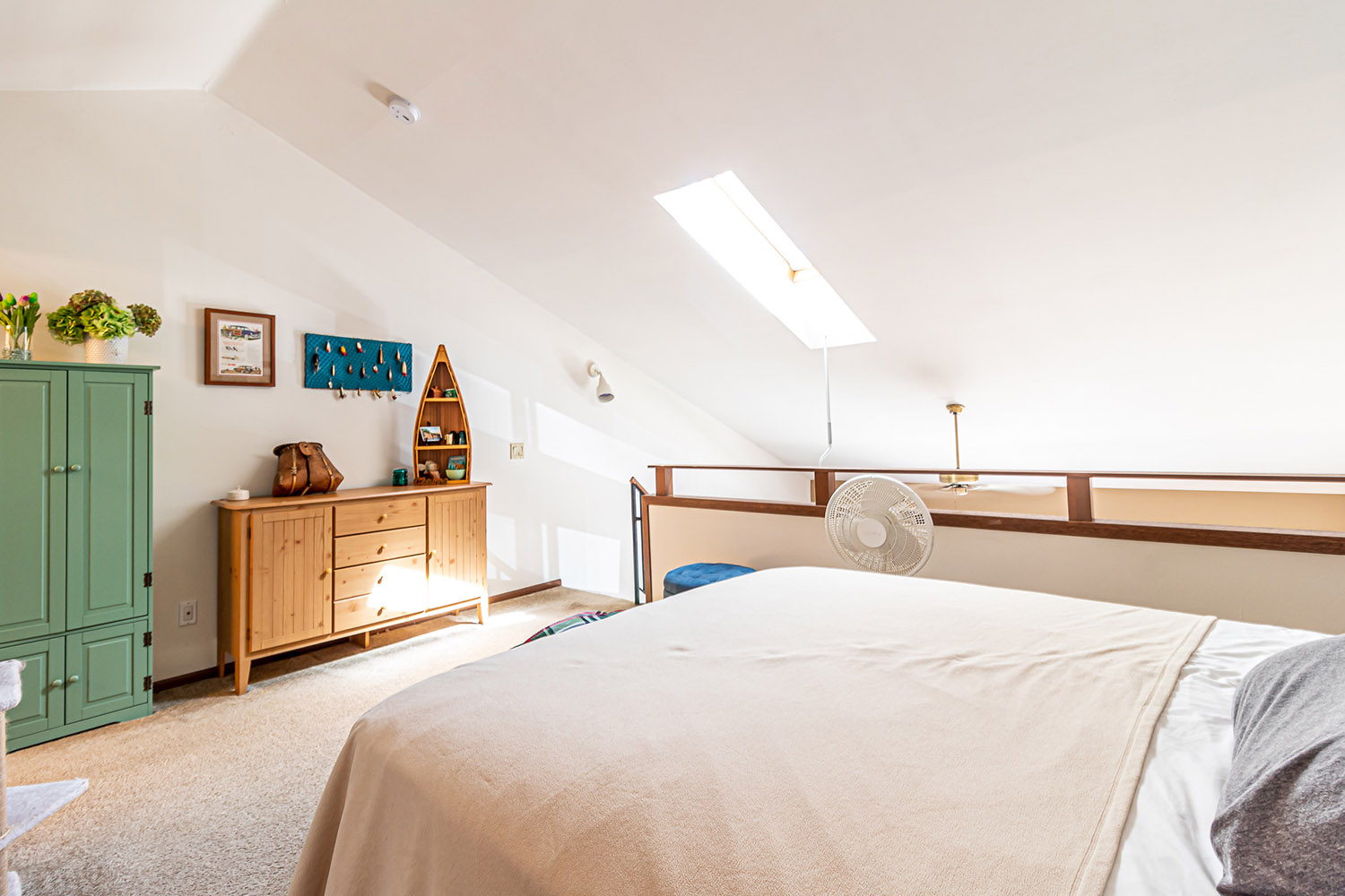 An apartment loft bedroom with a wardrobe, sideboard, and bed