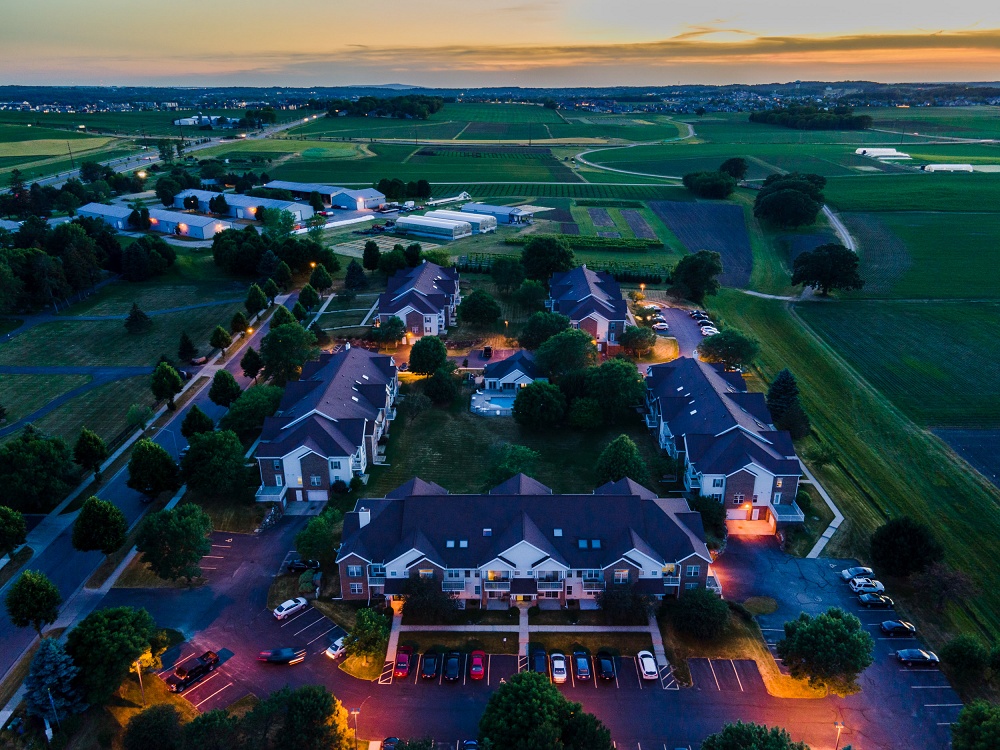 Aerial shot of apartment complex grounds surrounded by farmland at night