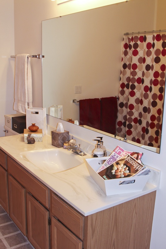 Bathroom countertop and sink in front of wall size mirror