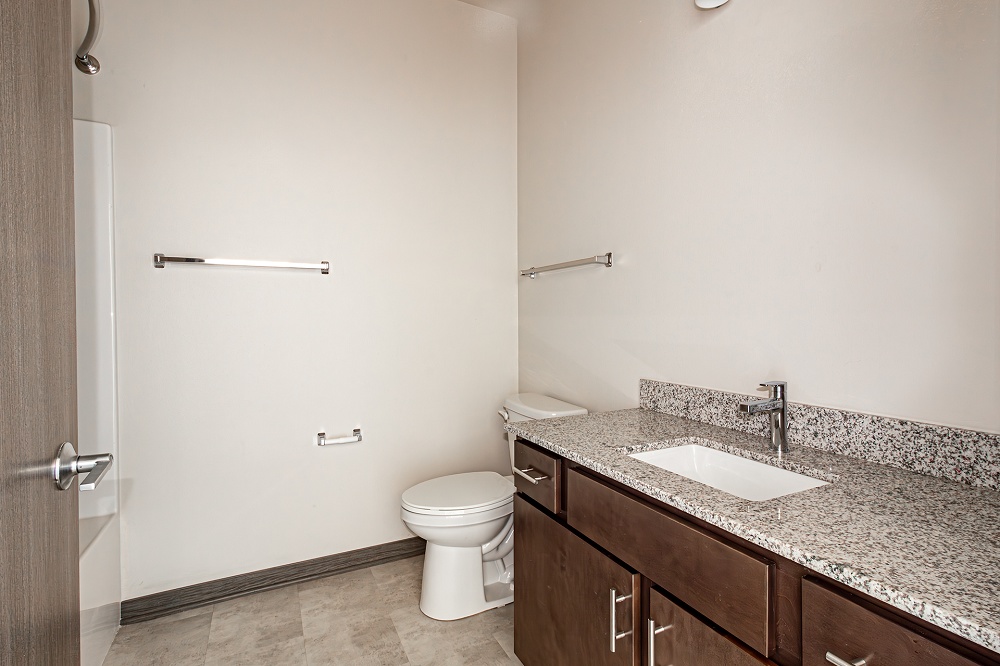 An empty arpartment bathroom with a toilet and sink