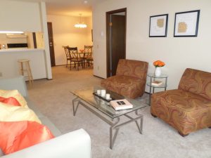 Living room with two chairs and coffee table, open to the dining area