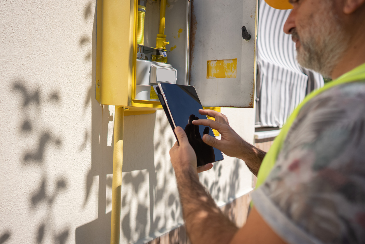 Close up technician repairing Gas Furnace using digital tablet