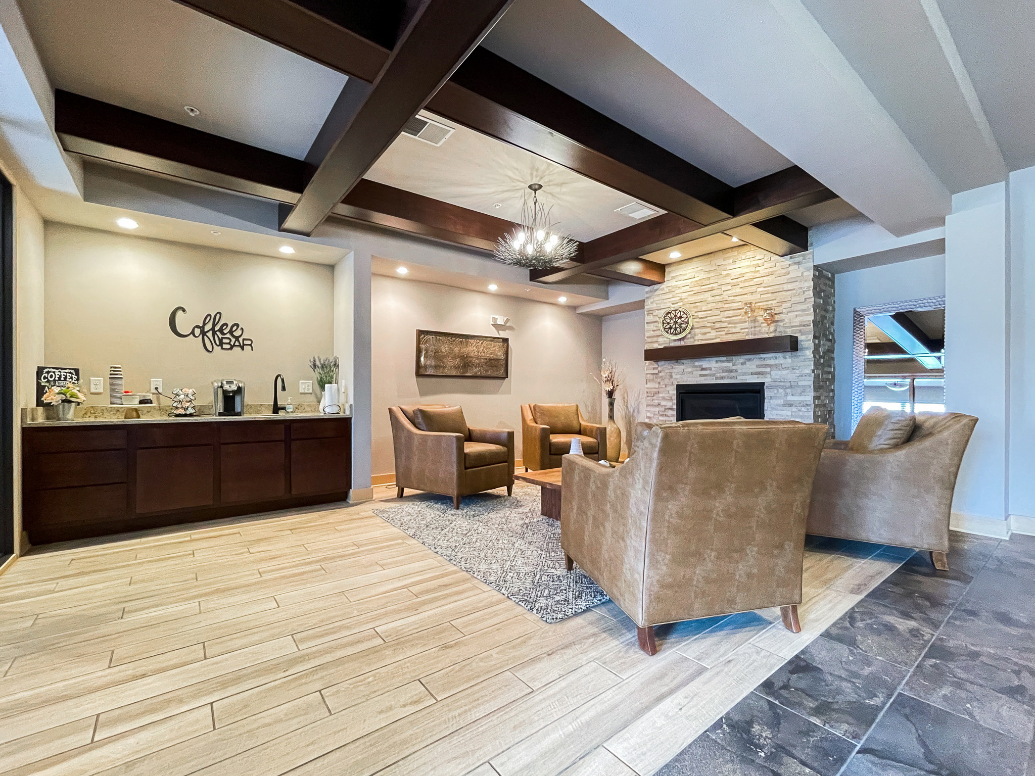 A coffee bar on the left and armchairs around a fireplace on the right