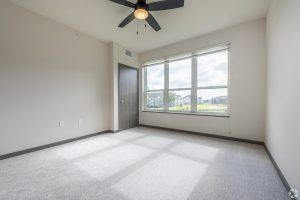an empty apartment bedroom with a ceiling fan
