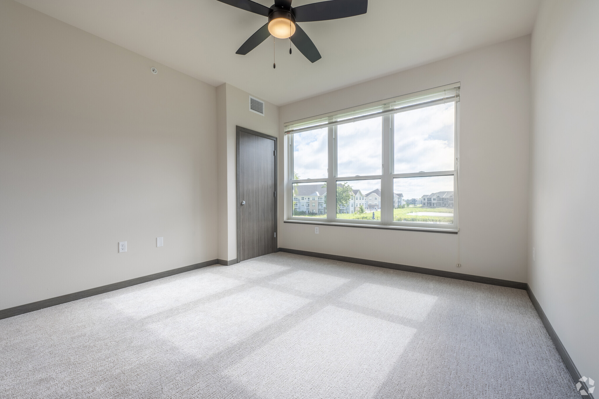 an empty apartment bedroom with a ceiling fan