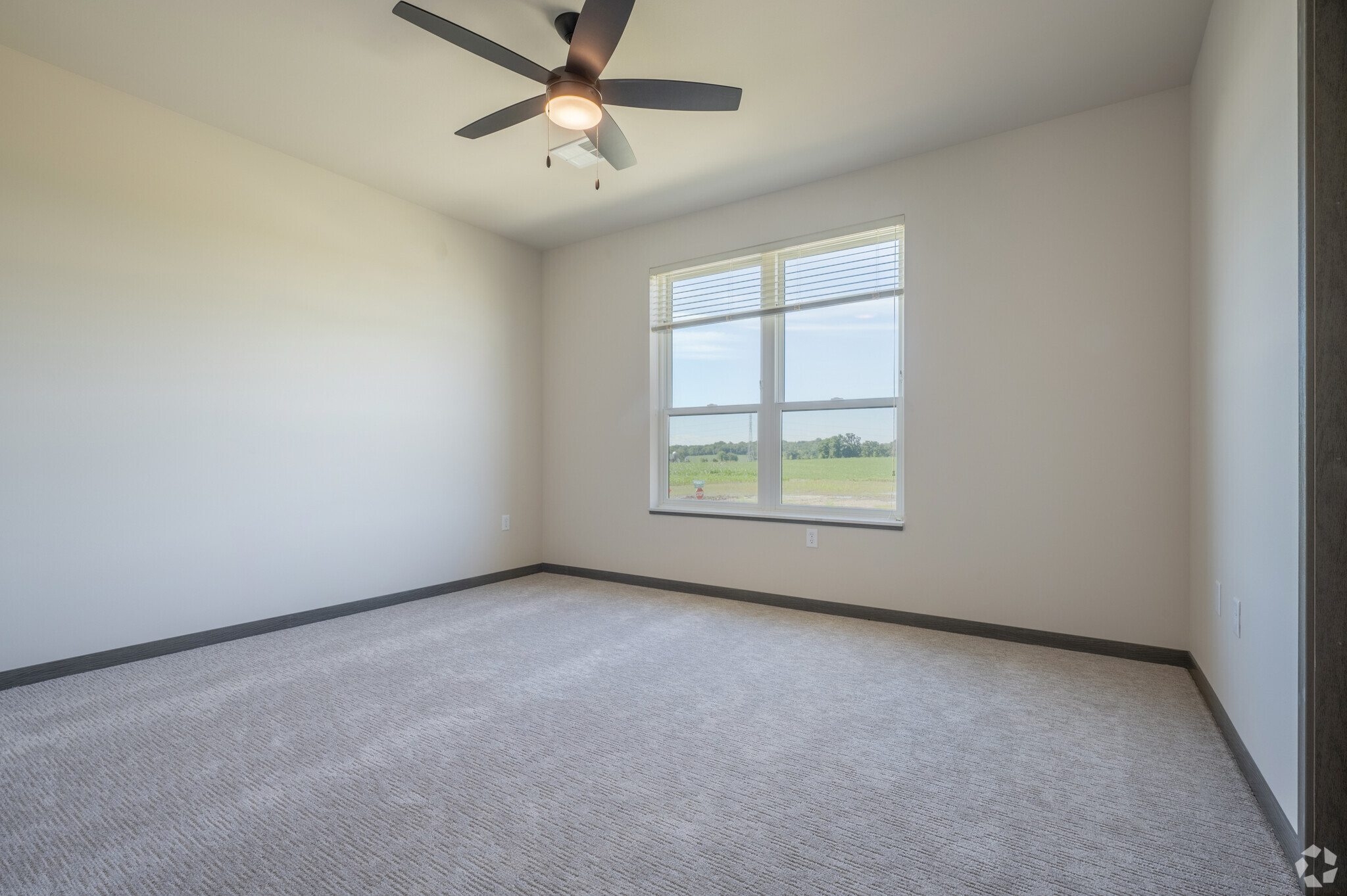 an empty apartment bedroom with a ceiling fan
