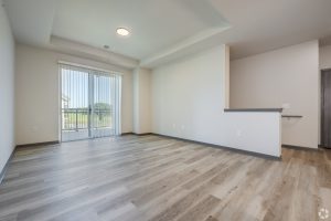 an empty apartment living room with window doors and a staircase