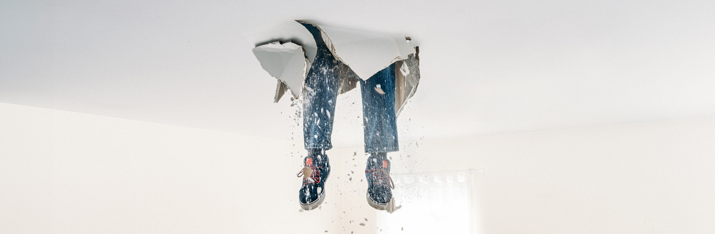 Person's legs break through ceiling drywall and are dangling