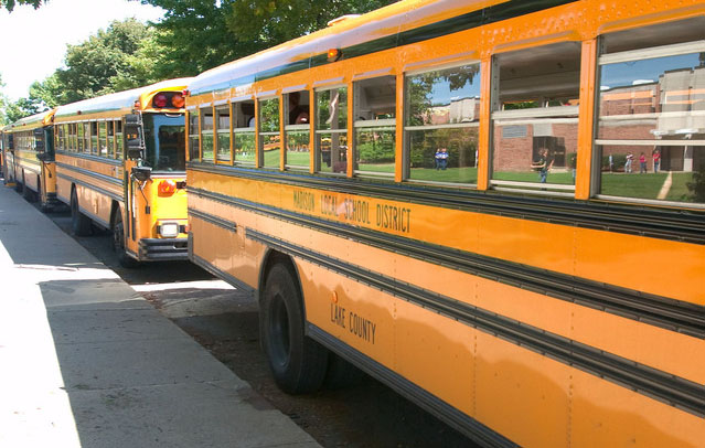 Public school buses parked in a line with doors open
